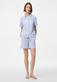 Blauw en witte gestreepte short-sleeve shirt met knopen en bijpassende korte broek, beide gemaakt van een lichtgewicht stof. Heeft een kraag en zakken.