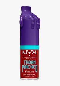 Farvejusterende læbeolie fra Thorn Pricked i en transparent rød beholder med en blank lilla håndtag og turkise detaljer. 0,16 fl. oz.