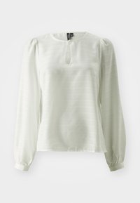 Blusa bianca a maniche lunghe in tessuto leggero, con scollatura a chiave e sottili righe verticali. Maniche a palloncino con polsini aderenti.