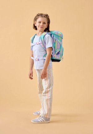 Rugzak met een kleurrijk, verloopachtig patroon met afgeronde vormen, verstelbare riemen en een patch met een figuur. Draagt door een kind in gestreepte broek.