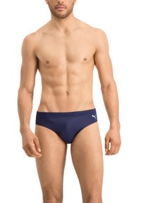 Marineblaue Schwimmslips mit einer glatten Textur und einem breiten Bund. Auffälliges weißes Logo an der Seite. Klassisches Low-Rise-Design für minimale Abdeckung.