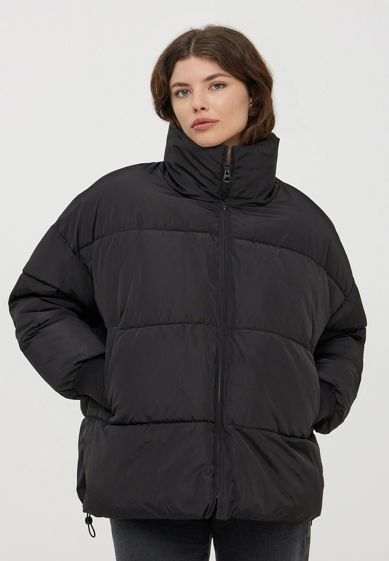 Giacca a vento nera con alto colletto, caratterizzata da un design a righe orizzontali, chiusura con zip e polsini elasticizzati. Texture morbida e liscia.