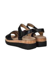 Zwarte leren sandalen met een kurken tussenzool en een zwarte rubberen outsole. De banden hebben een open ontwerp voor ademend vermogen en comfort.