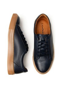 Granatowe skórzane sneakersy z perforowanymi detalami, płaskimi sznurowadłami i brązowymi gumowymi podeszwami. Posiadają gładkie i teksturowane powierzchnie.