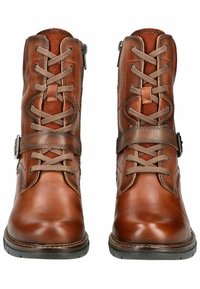 Botas de cuero marrón hasta el tobillo con un acabado suave, con cordones, una correa decorativa con hebilla y una suela de goma resistente.