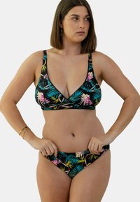 Bikini noir à fleurs avec un décolleté plongeant, présentant des motifs de plantes tropicales en rose et vert, avec des bretelles réglables et une texture de tissu lisse.