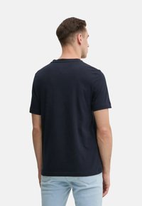 T-shirt a maniche corte blu navy con scollatura a girocollo, realizzato in cotone morbido, caratterizzato da una vestibilità rilassata e dettagli minimi sul retro.