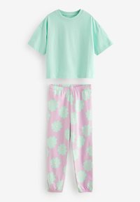 Haut en coton turquoise à manches courtes assorti à un pantalon de jogging rose orné de grandes fleurs vert menthe avec des centres blancs, taille élastique.