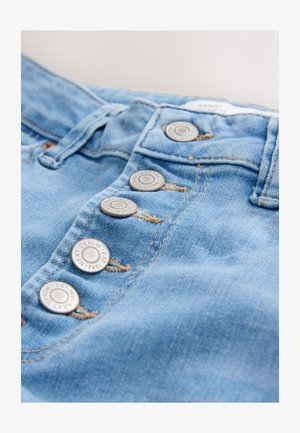 Šviesiai mėlynos spalvos džinsai iš džinsinio audinio su keturiais metaliniais mygtukais, matomomis siūlėmis ir lygiu audiniu.