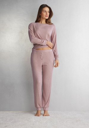 Lange mouwen roze pyjama top met ribbelstructuur en ronde halslijn, gecombineerd met bijpassende ribbelbroek met knoopsluiting en opgerolde enkels.