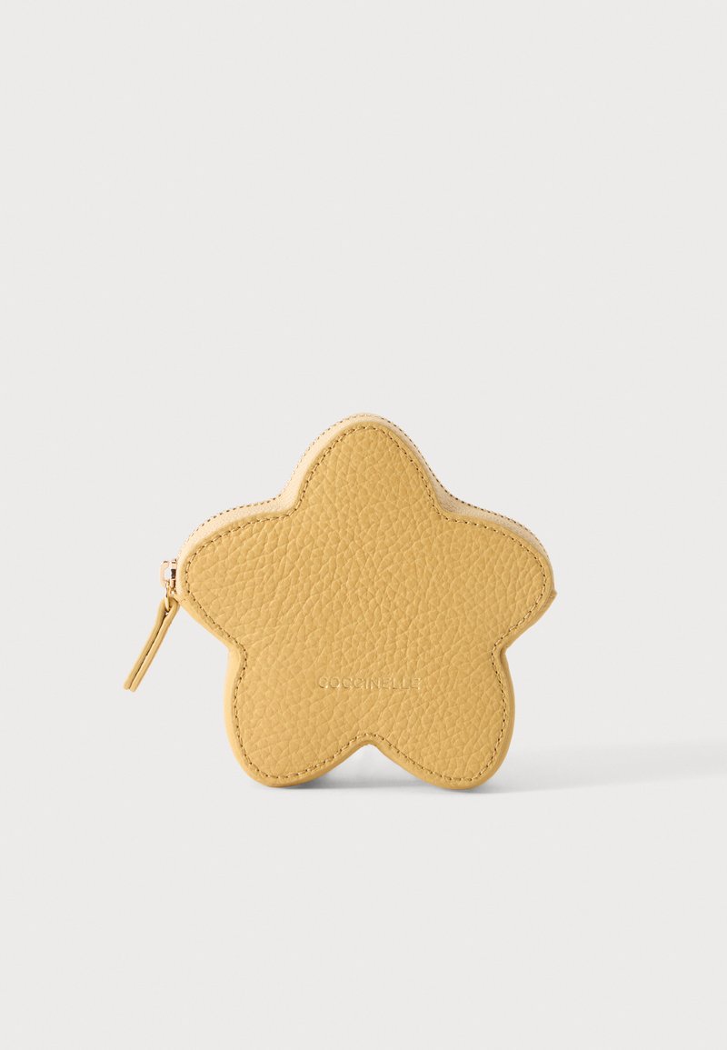 Porte-monnaie jaune en cuir texturé en forme d’étoile, avec une fermeture éclair sur le côté gauche, posé sur un fond clair et uni.