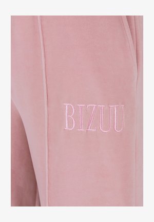 Różowe dresy z weluru z haftowanym logo "BIZUU" w dopasowanej nitce, o miękkiej fakturze i minimalistycznym designie.