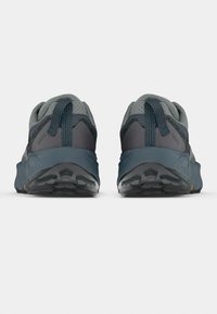 Chaussures de trail running grises avec des accents foncés. Tige en mesh, semelle coussinée et semelle extérieure robuste pour une adhérence optimale. Talon renforcé et languette de maintien.