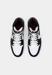 Pair of black, white, and brown high-top sneakers with white laces, viewed from above on a plain white background.