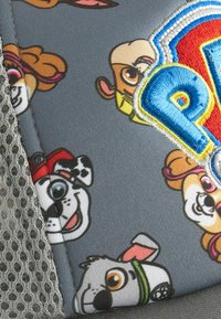 Grau Kappe mit gemusterten Cartoon-Hundcharakteren, Netz-Seitenpaneel und gesticktem "PAW Patrol"-Logo in blauen und roten Akzenten.