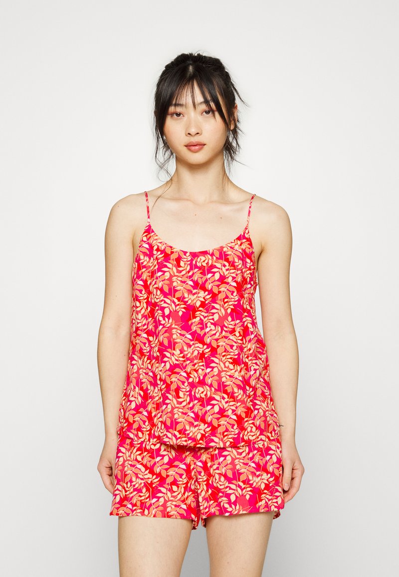 Camisola com padrão floral rosa, com alças finas, emparelhada com calções combinando. Tecido leve com uma textura suave.