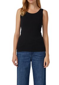 Haut noir sans manches en tissu doux et extensible avec un col arrondi. Porté avec un jean en denim bleu ample, présentant une coupe droite et un lavage clair.