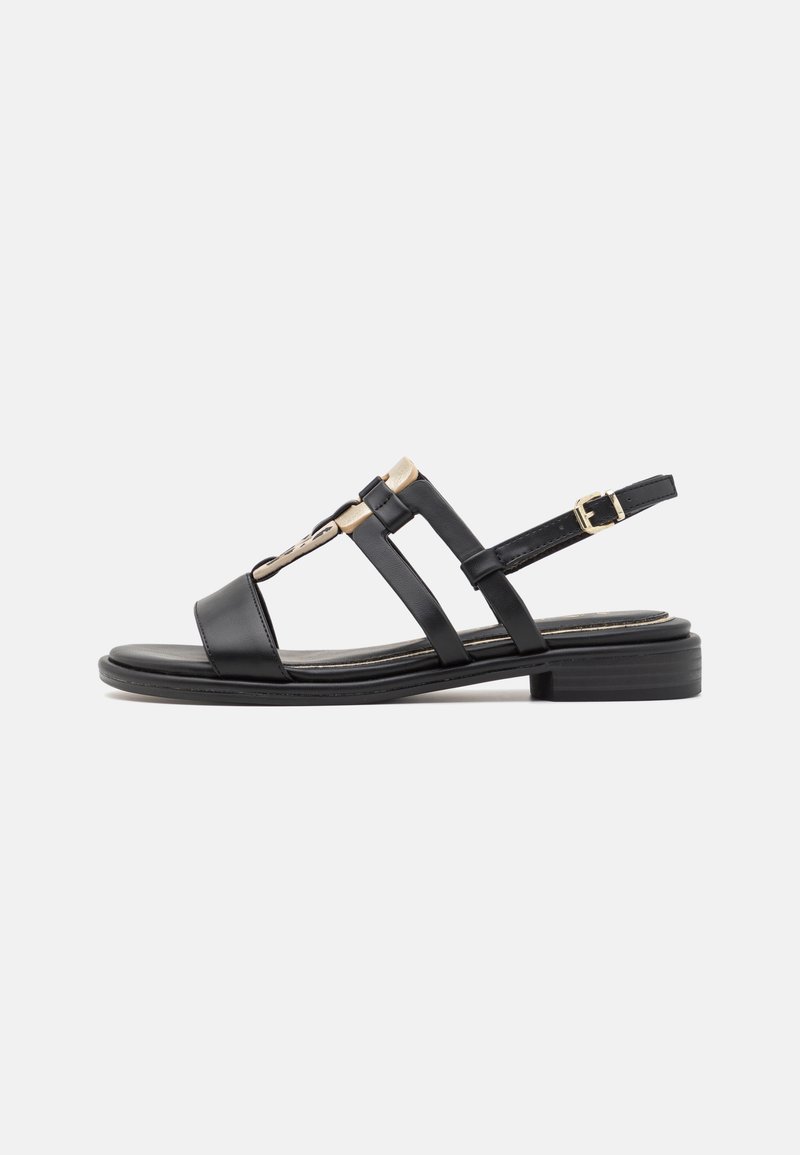 Black leather sandal featuring multiple straps, a low block heel, and a gold accent on the toe area. Adjustable buckle closure at the back.