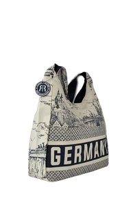 Tote bag en toile avec une illustration détaillée en noir et blanc de monuments allemands, avec un texte "GERMANY" en bleu marine uni et un logo accent.