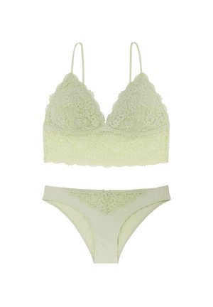 Šviesiai žalias nėriniuotas braletas su reguliuojamomis dirželiais ir atitinkamomis nėriniuotomis bikini kelnaitėmis. Minkšta tekstūra su gėlių raštais ir dviem kaspinais.