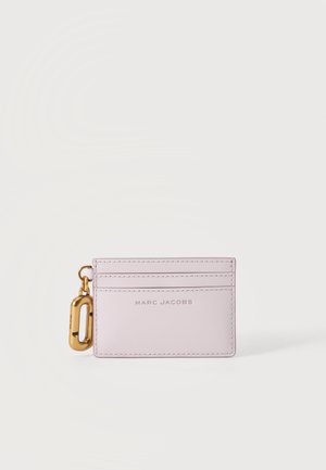 Светлорозов калъф за карти Marc Jacobs с три отделения за карти и златист клипс от лявата страна на бял фон.