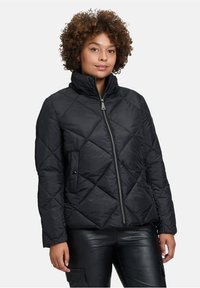 Sort kviltet pufferjakke med høj krave, der har en frontlynlås, to forlommer og et geometrisk design med glans.