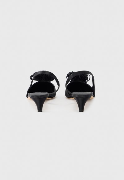 Czarne czółenka z odkrytymi palcami na niskim, cienkim obcasie. Wykonane z miękkiego materiału z marszczonym paskiem z tyłu. Gładkie wewnętrzne wyściółki.