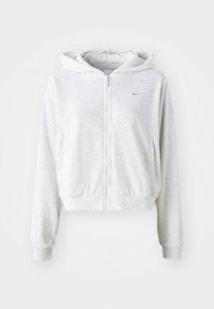 Felpa zip grigia chiara realizzata in tessuto morbido, con tasca frontale, polsini a costine e cappuccio. Logo Nike in grigio scuro sul petto.