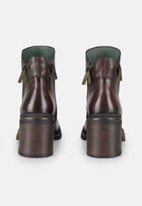 Stivaletti in pelle marrone con tacco texturizzato, cerniere laterali e interno verde. Caratterizzati da una punta arrotondata e design del tacco rigato.