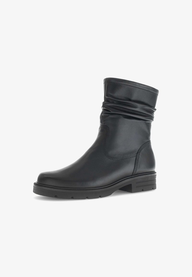 Botte en cuir noire mi-mollet avec une tige lâche, un bout arrondi, un petit talon et une semelle en caoutchouc texturée, vue de profil sur fond blanc.