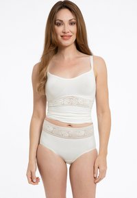 Completo di lingerie bianco che presenta un top aderente con bordature in pizzo in vita e slip a vita alta con una fascia in pizzo coordinata. Tessuto morbido.