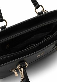 Borsa a mano nera in pelle con hardware dorato, interno con cerniera, esterno testurizzato e un ampio scomparto con fodera in tessuto e tasche.