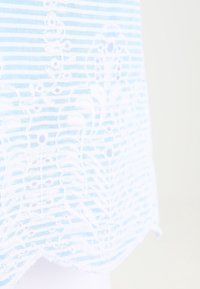 Tissu bleu clair avec des rayures horizontales et un motif de dentelle florale blanche en superposition, avec un détail d'ourlet festonné.