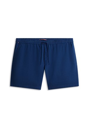 Moške kopalke temno modre barve z elastičnim pasom, vrvico za vezanje in stranskimi žepi, položene ravno na belem ozadju.