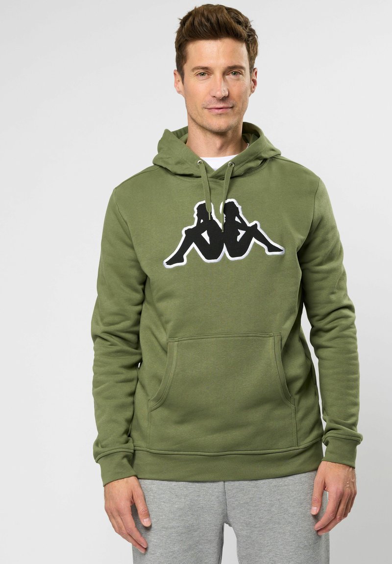 Olivovo zelená mikina s kapucňou vyrobená z bavlneného zmesového materiálu, s prednou klokankou a čiernym logom na hrudi. Hladká textura.