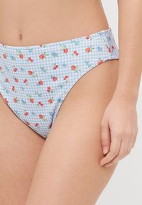 Svetlo modri bikini hlački s karirastim vzorcem, okrašeni z malimi rdečimi jagodami in češnjami. Gladka tkanina z šivanimi šivi.