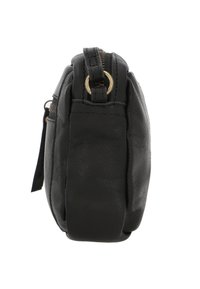 Compacte zwarte leren crossbodytas van opzij getoond, met ritssluiting en metalen ringdetail op de lus van de band.