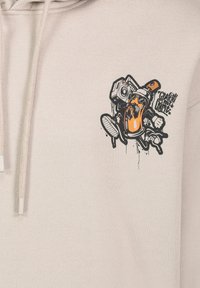 Beige Kapuzenpullover mit einem grafischen Druck eines Charakters, der eine Sprühdose und einen Boombox hält. In Schwarz und Orange gezeichnet, mit Spritzdetails.