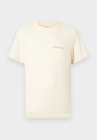 Μπεζ βαμβακερό μπλουζάκι με κοντά μανίκια και στρογγυλή λαιμόκοψη. Διαθέτει μικρό κόκκινο κεντητό λογότυπο της μάρκας στο αριστερό στήθος.