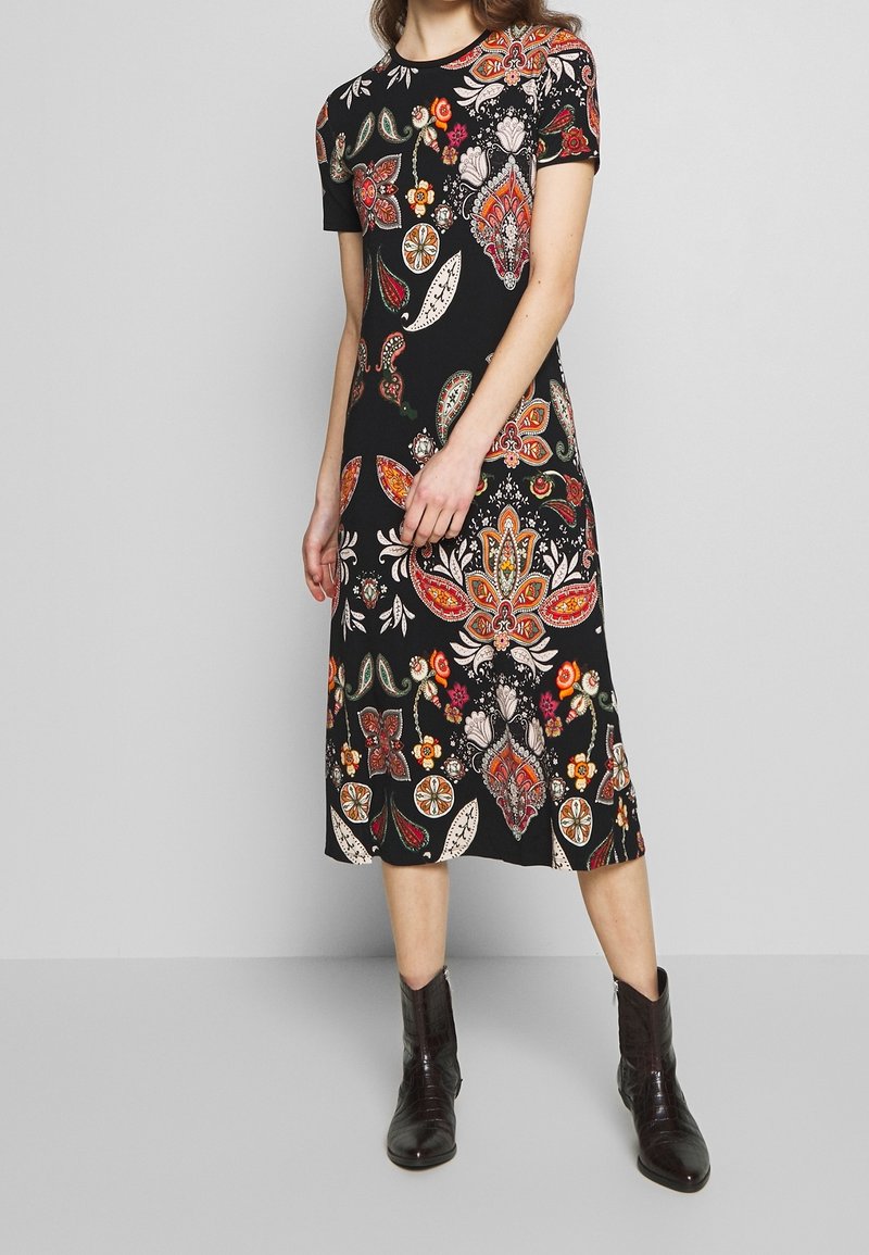 Robe noire à manches courtes présentant un motif coloré floral et paisley, coupe décontractée, longueur au genou et tissu léger.