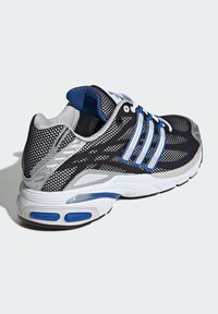 Scarpa sportiva in mesh nera e argento con dettagli blu, dotata di tre strisce bianche, colletto imbottito e ammortizzazione ad aria visibile nella suola.