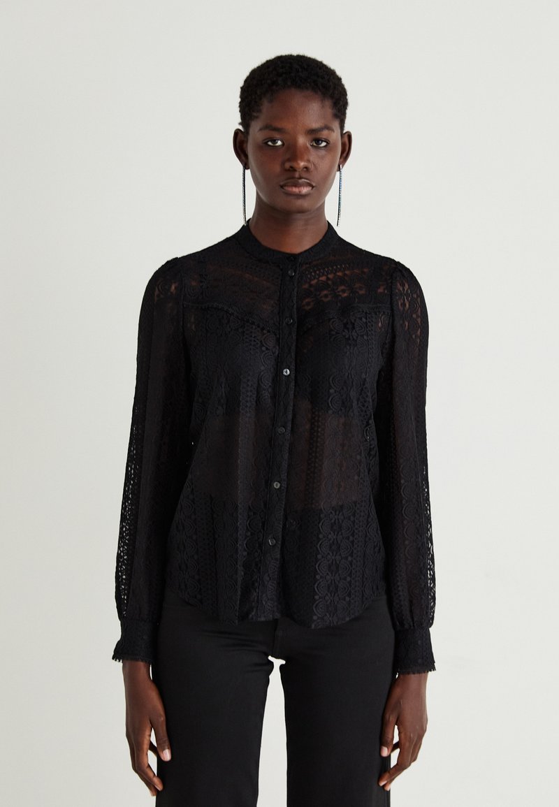 Schwarze Spitzenbluse mit langen Ärmeln, floralem Muster und transparenten Abschnitten, mit durchgehender Knopfleiste und rundem Kragen. Details umfassen strukturierte Akzente.