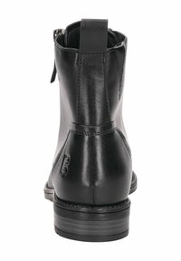 Botas de tobillo de cuero negro con acabado suave, una tiras en la parte trasera y un tacón apilado. Diseñadas con una silueta limpia y un hardware mínimo.