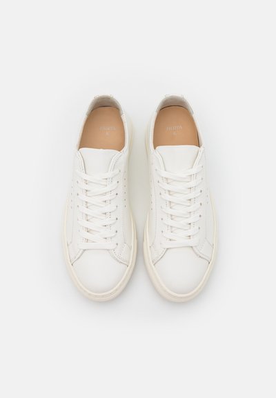 White leather sneakers with a smooth texture, round toe, and flat laces; soft insole with subtle brand logo; rubber sole.