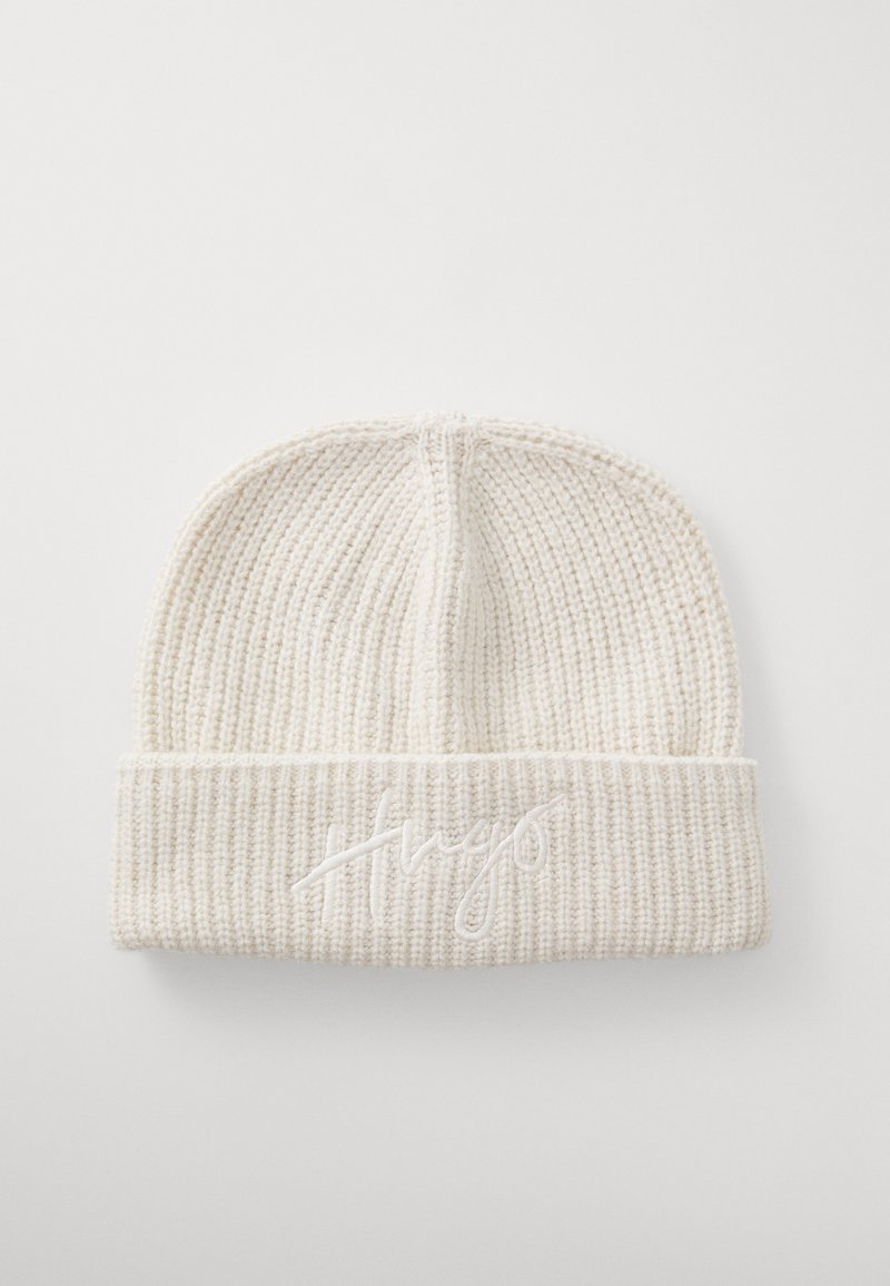 Kreemi värvi ribakudumi beanie, millel on volditud serv ja millel on samaväärse niidiga brodeeritud sõna "Hugo".
