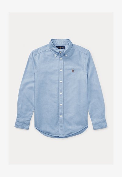 Svete modra srajca s dolgimi rokavi, ovratnikom in belimi gumbi. Ima majhen vezen logotip na prsih. Gladka tekstura.