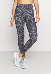 Leggings a vita alta in un motivo camouflage grigio scuro, realizzati in materiale elasticizzato, con una texture liscia e design alla caviglia.
