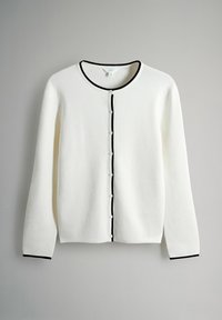 Cardigan alb cu margini negre, guler rotund și închidere cu nasturi în față. Materialul pare moale, cu dungi pe manșete.
