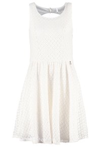 Robe sans manches blanche en dentelle, avec un col rond, une jupe évasée et une découpe en forme de trou de serrure au dos avec un petit accent métallique.