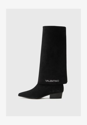 Botines de ante negro hasta el tobillo con puntera afilada, tacón cuadrado y un puño alto. Presenta un logo "Valentino" embellido con cristales en un lado.
